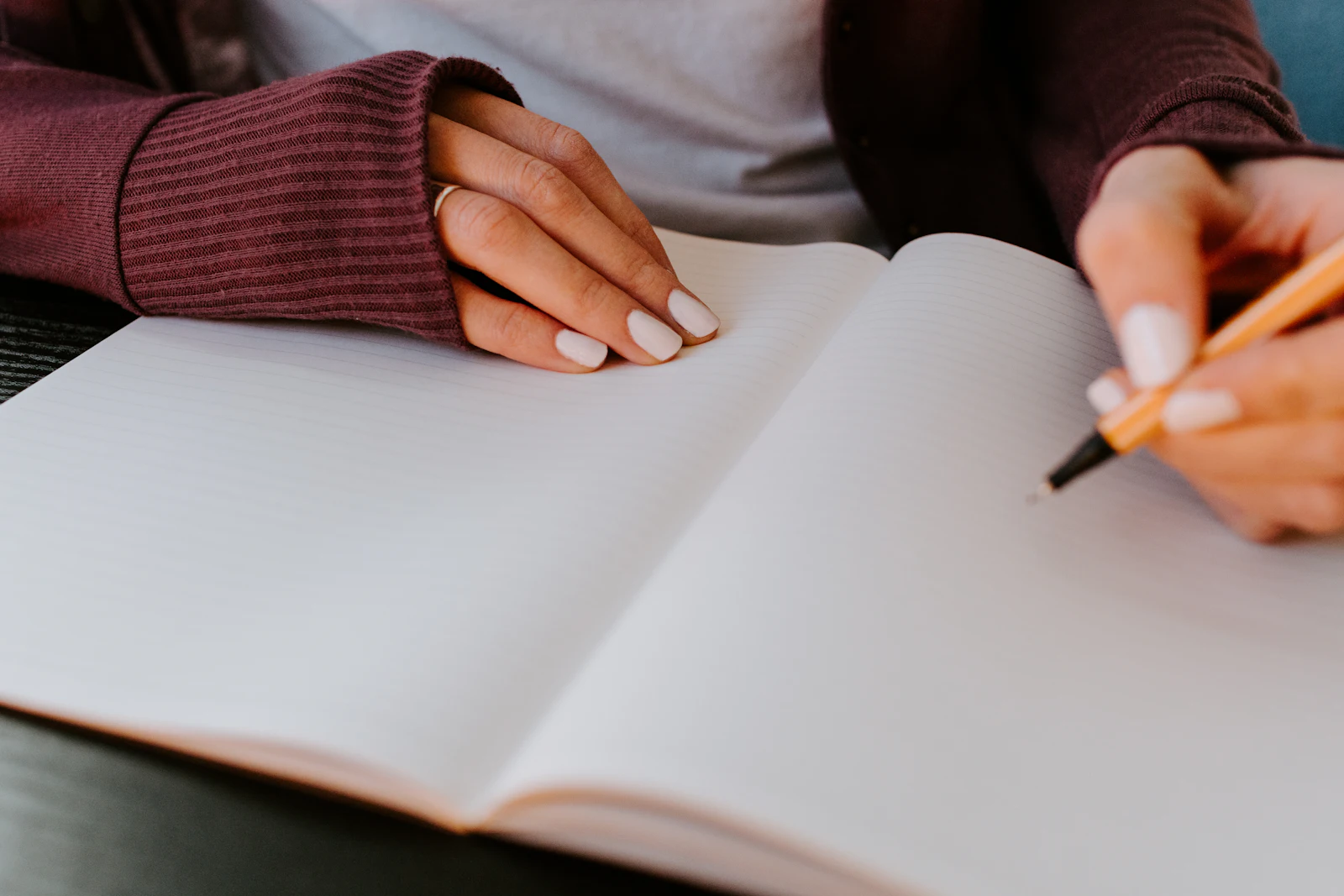 Handen boven een open schrift, met een pen in de aanslag